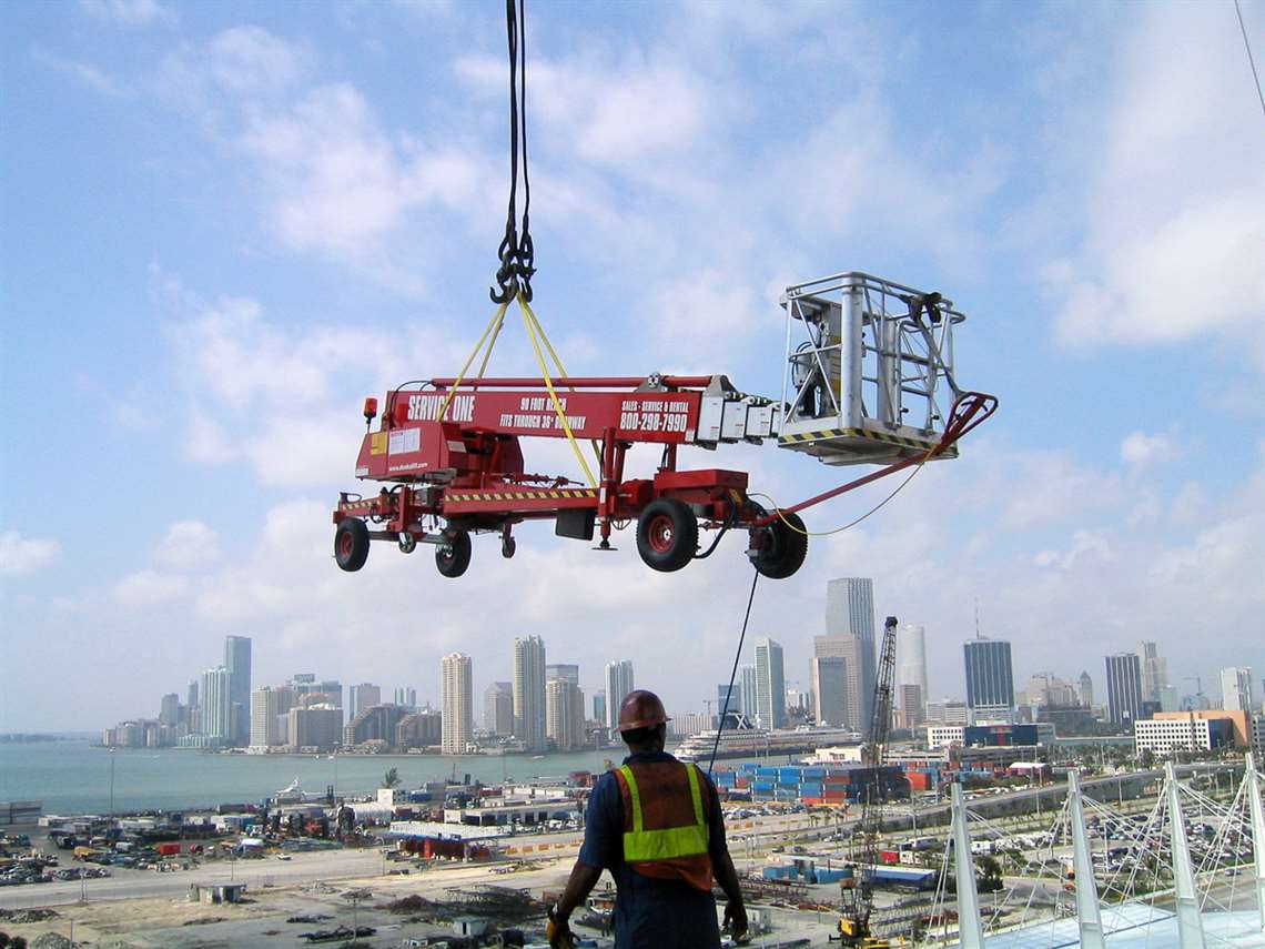 A Denka Lift model is lifted by crane over the city.