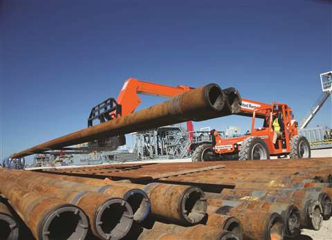 A United Rentals telehandler lifting industrial pipes